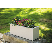 Rechthoekige kunststof plantenbak met bloemen op stenen muur