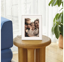Digitale fotolijst op een ronde houten bijzetter in de woonkamer, toont een familiefoto