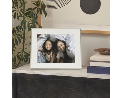 Eenvoudige fotolijst met passe-partout op een dressoir, met een foto van twee kinderen.
