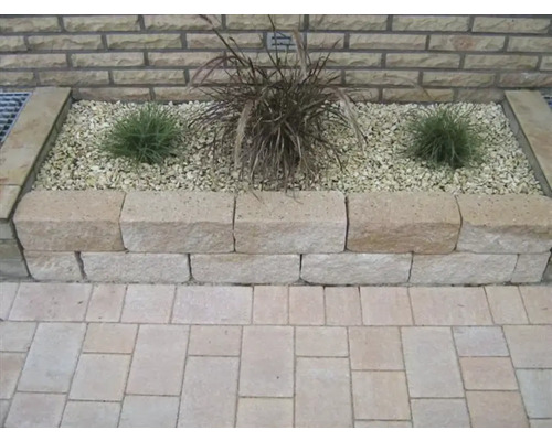 Verhoogde tuinbed met planten en stenen in de tuin