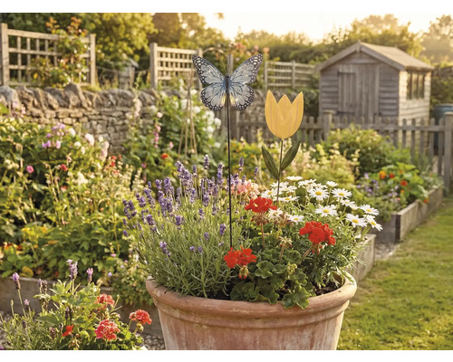 Tuinoverzicht met bloembed, decoraties en tuinhuisje