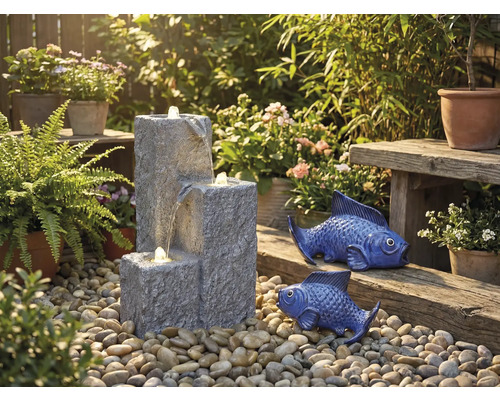 Tuinscene met trapsgewijze fontein, decoratieve vissen en planten