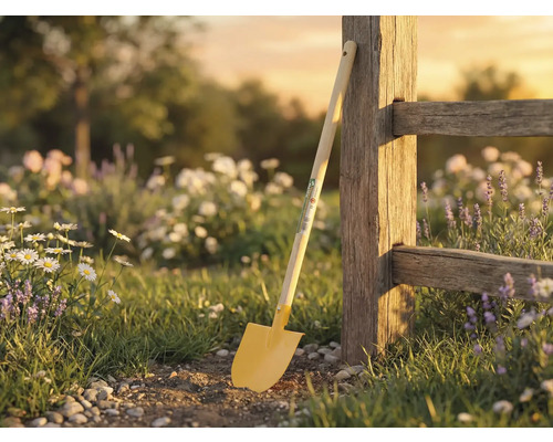 Tuinscene met spade tegen houten hek