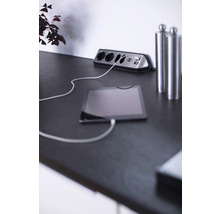 Stekkerdoos met USB-poorten en aangesloten tablet op een tafel