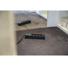 Verlengdoos met vijf aansluitingen op tapijt