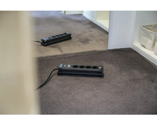 Verlengdoos met vijf aansluitingen op tapijt