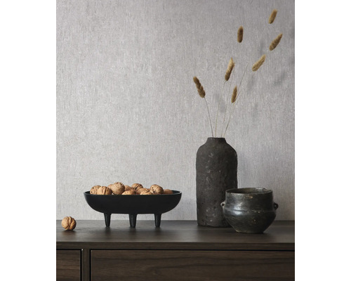 Decoratieve scène met een schaal noten, een vaas met droogbloemen en een keramische pot op een tafel