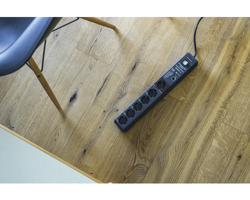 Verlengdoos met zes stopcontacten op houten vloer