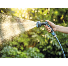 Hand houdt tuinslang met sproeikop vast