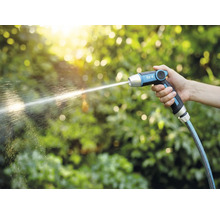 Een hand houdt een for_q tuinspuit vast waar een waterstraal uit komt.