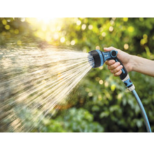 Tuinslang met sproeikop in gebruik