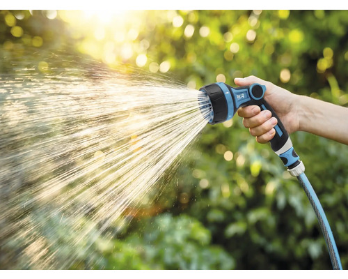 Tuinslang met sproeikop in gebruik