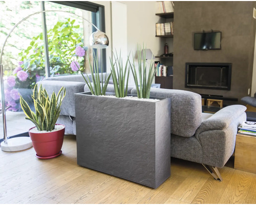 Woonkamer met plantenbakken en bank voor een lichte en vriendelijke sfeer.