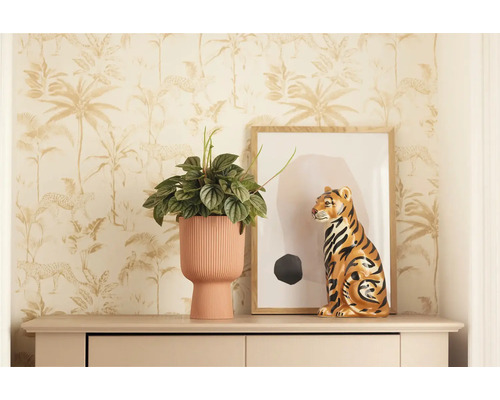 Decoratieve scène met kamerplant in geribbelde pot, tijgerbeeld en ingelijst kunstwerk op dressoir voor junglebehang.
