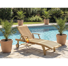 Scene met een houten ligstoel, een cocktail en planten bij een zwembad.