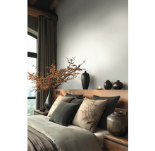 Slaapkamer met houten bed, kussens, dekens en vazen