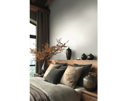 Slaapkamer met houten bed, kussens, dekens en vazen