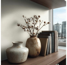 Decoratief arrangement met twee vazen, katoentakken en boeken op een plank.