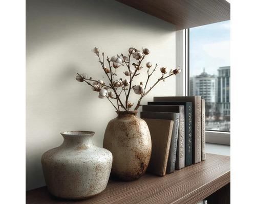 Decoratief arrangement met twee vazen, katoentakken en boeken op een plank.