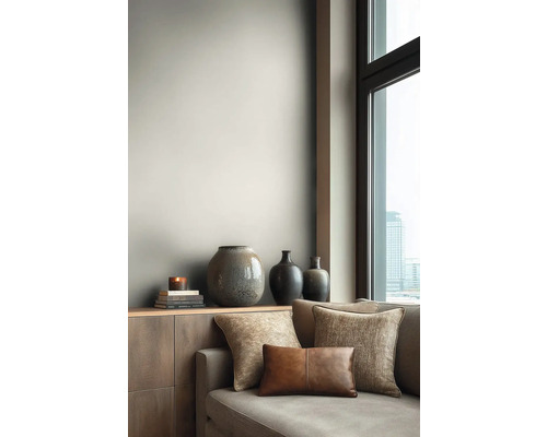 Woonkamer met bank, kussens en decoratieve vazen op een dressoir