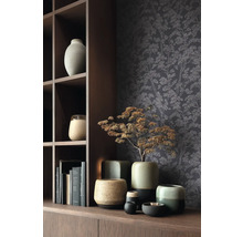 Decoratieve scène met diverse keramische vazen en behang met boommotief op een houten plank.