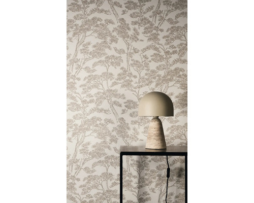 Vliesbehang met bruin dennenpatroon op een muur achter een moderne tafellamp op een zwarte metalen tafel.