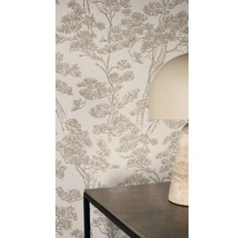 Lichte woonruimte met vliesbehang met getextureerd dennenontwerp op een muur achter een tafel en een tafellamp.