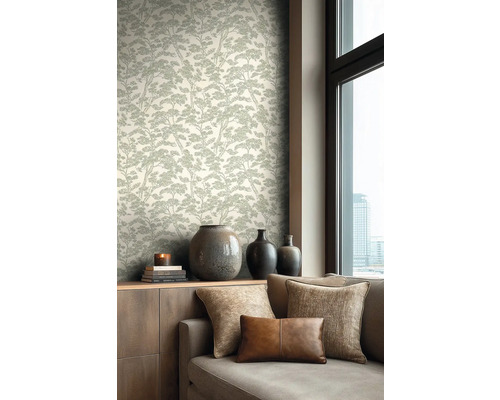 Lichte, modern ingerichte woonkamer met behang met boompatroon, een houten dressoir met vazen en een bank met kussens.