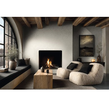 Moderne woonkamer met haard, getextureerde muren en houten plafondbalken. Fauteuils, een houten tafel en een gezellige vensterbank.