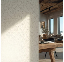 Behang met een verfijnd bloemenpatroon in een lichte woonkamer met een houten tafel en houten plafond.