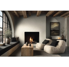 Gezellige woonkamer met brandende open haard, twee teddy fauteuils, salontafel van massief hout en houten plafondbalken in moderne landelijke stijl.