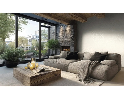 Moderne woonkamer met bank, rustieke houten tafel, stenen haard en grote raampartijen met uitzicht op planten en gebouwen.