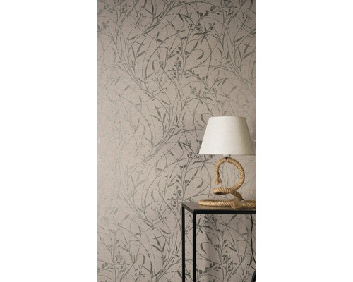 Close-up van een behang met plantenmotief en een tafellamp op een tafel