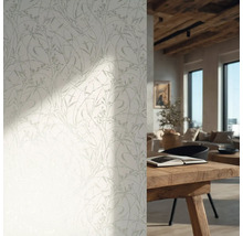 Behang met fijn takjespatroon in een lichte, rustieke woonkamer met houten tafel en houten plafondbalken.