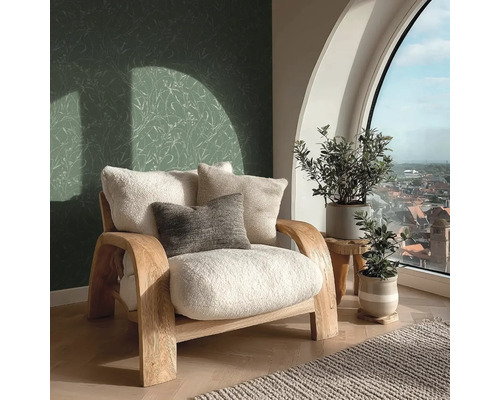 Lichte kamer met fauteuil, kussens, planten en uitzicht uit het raam