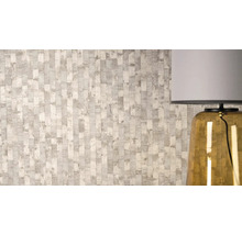 Vliesbehang met gestructureerd verticaal strepenpatroon en metallic accenten naast een tafellamp.