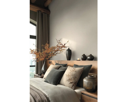 Slaapkamer met bed, kussens, vazen en decoratieve elementen voor een rustige sfeer