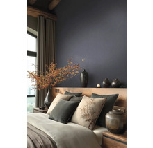 Moderne slaapkamer met donker structuurbehang, houten bed, kussens met boommotief en decoratieve vazen met bessentakken.