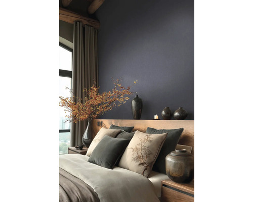 Moderne slaapkamer met donker structuurbehang, houten bed, kussens met boommotief en decoratieve vazen met bessentakken.