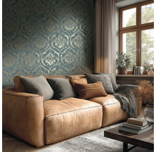 Woonkamer met bruine leren bank, kussens, deken, houten tafel, raam en behang met patroon voor een gezellige sfeer