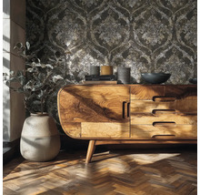 Woonkamerscène met vliesbehang met ornamentpatroon, een houten dressoir en visgraat parketvloer.