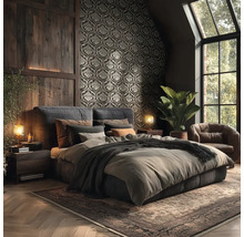 Donkere slaapkamer met behang met ornamenten, houten wandpanelen, gestoffeerd bed, leren fauteuil en vloerkleed in rustieke stijl.