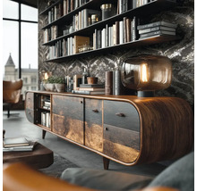 Rustiek houten dressoir met afgeronde hoeken in een woonkamer met behang met patroon, boekenplanken en een glazen tafellamp.