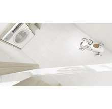 Wasmachine, witte tegels en een speelgoedauto in de badkamer