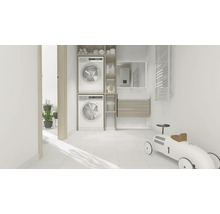 Lichte wasruimte met wasmachine, droger en badkamermeubels.