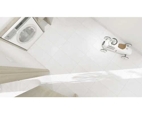 Wasmachine, witte tegels en een speelgoedauto in de badkamer