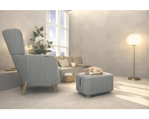 Woonkamer met fauteuil, voetenbank, vloerlamp en een kat die op de voetenbank slaapt