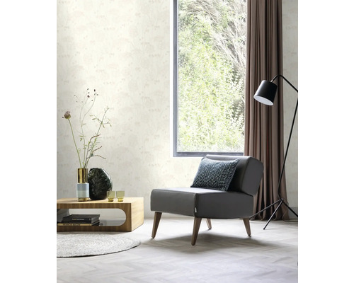 Woonkamer met fauteuil, salontafel en behang met bloemmotief