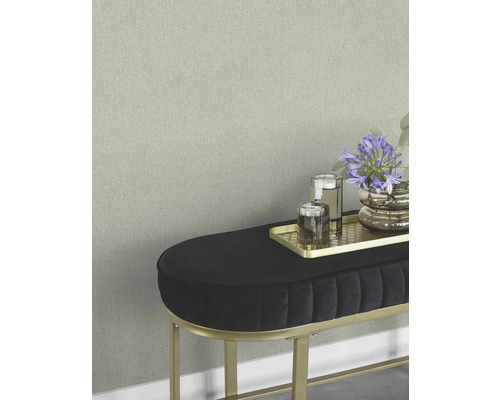 Close-up van een wand met subtiel behang en een bank met decoratie