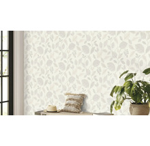 Woonkamer met behang met bladerpatroon, hoed, kussen en kamerplant